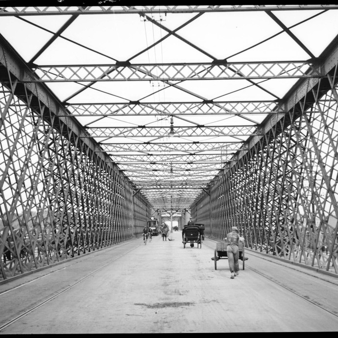 Menschen unterwegs auf einer Brücke mit Stahlkonstruktion (vergrößerte Bildansicht wird geöffnet)