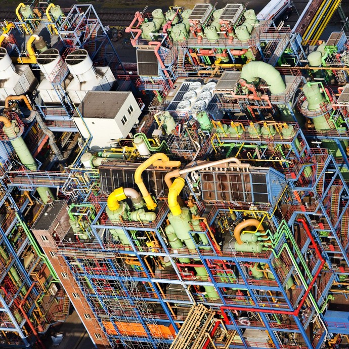 Luftaufnahme einer Chemiefabrik mit farbigen Kesseln und Rohrleitungen. (öffnet vergrößerte Bildansicht)