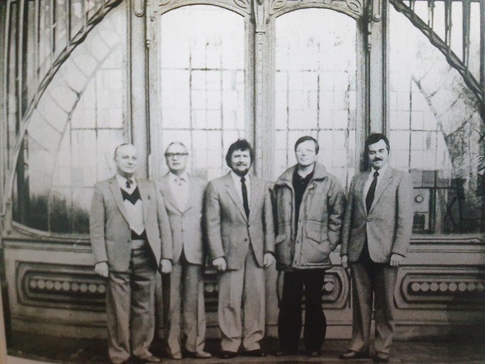 Eine Schwarzweißaufnahme von fünf Männern vor dem Jugendstil-Portal der Maschinenhalle der Zeche Zollern.