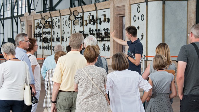 Gruppe von Besuchern und Besucherinnen vor der Schalttafel in der Maschinenhalle. Gruppe von Besuchern und Besucherinnen vor der Schalttafel in der Maschinenhalle.
