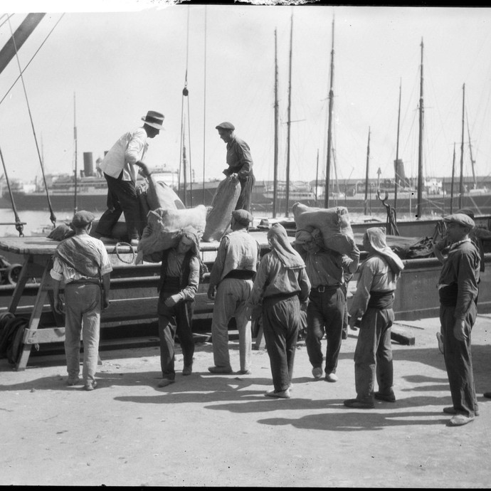 Hafenarbeiter beladen ein Schiff (vergrößerte Bildansicht wird geöffnet)
