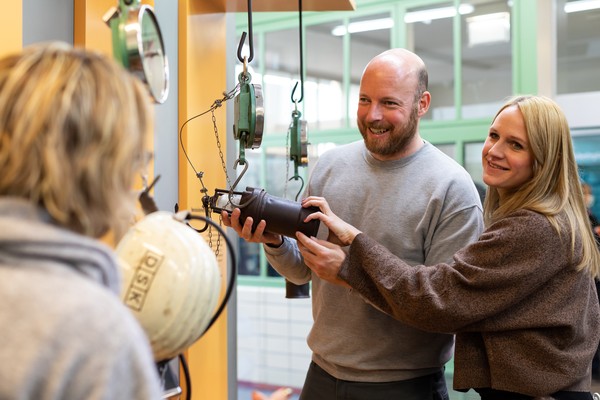 Ein junges Paar in der Ausstellung hält eine Grubenlampe in den Händen.