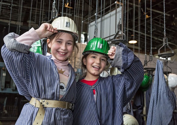 Zwei Kinder in Grubenhemden und mit Helm
