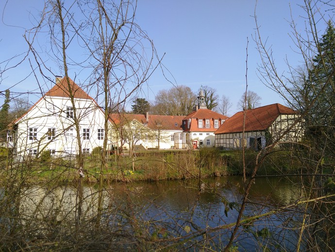 Weiße Gebäude vom Gut Eckendorf vor einem Teich