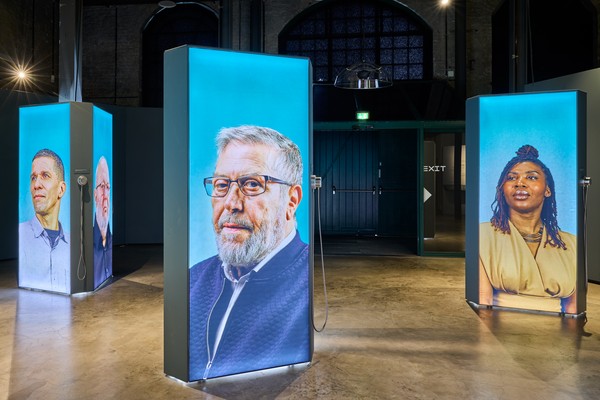 Blick in die Ausstellung auf verschiedene Aufsteller mit abgebildeten Personen