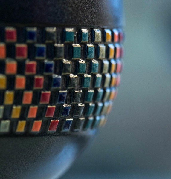 Detailansicht einer dunklen Keramikvase mit farbig glasierten Quadraten